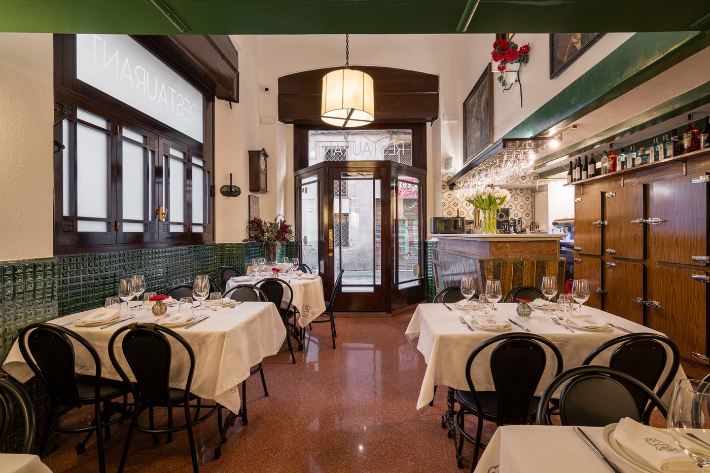 Sala d’entrada de Can Lluís, amb rajola verda i taules parades