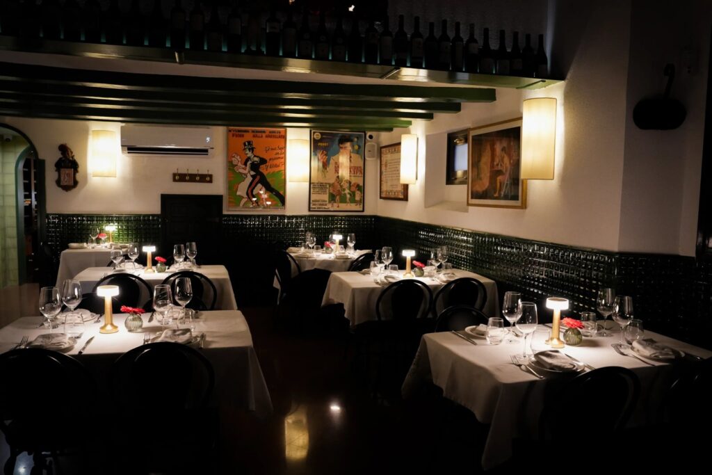 Sala de Can Lluís al vespre, amb cartells de teatre a la paret, a pocs minuts dels teatres del Raval